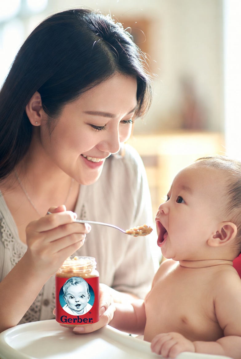 A mother feeding her baby Gerber baby food – symbolizing the spoon-fed truth of The Gerber Approach